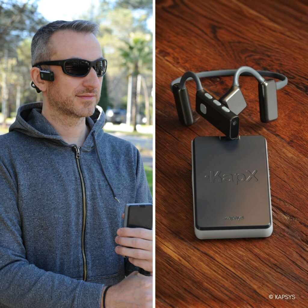 Links: Mann mit Sonnenbrille und KapX-Gerät am Ohr hält ein Smartphone. Rechts: KapX von Kapsys auf Holztisch, kombiniert mit Knochenleitungs-Headset.