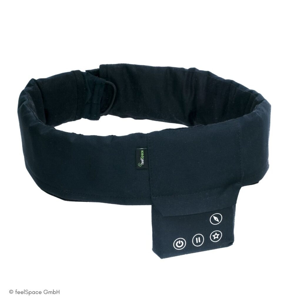 Schwarzer feelSpace-Navigationsgürtel mit gepolstertem Band und integrierter Steuereinheit mit Power-, Pause- und Navigationstasten.