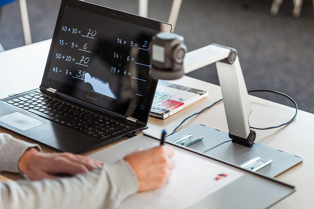 A student solves math problems with the ZoomCam camera system