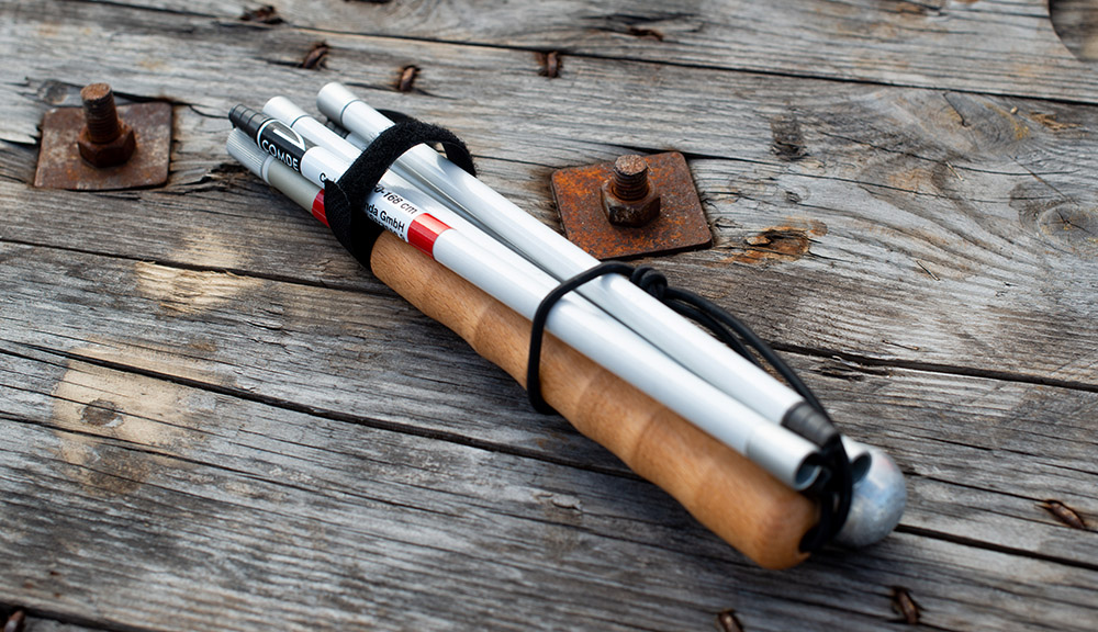 Telefolding cane, folded on a wooden barrel