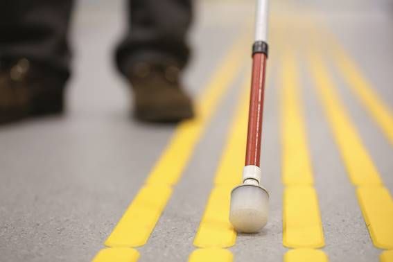 Tip of a cane for the blind on a yellow guiding strip